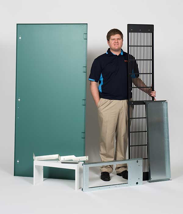 guy standing with metal appliances needing sheet metal fabrication Dallas